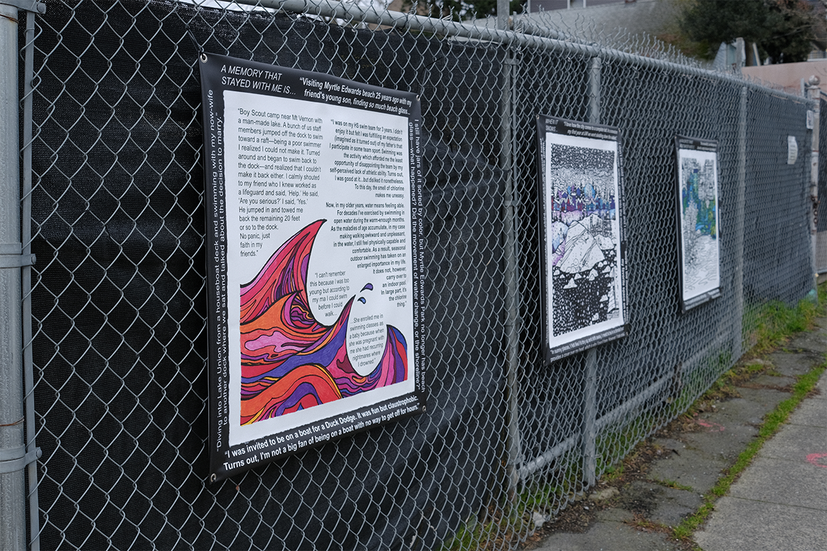 This photo shows posters secured to a chain link fence with a black construction screen. The posters contain water-related images and original quotes.