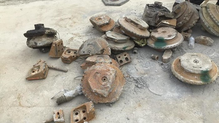 A pile of dirty machinery pieces that are MudHoney’s cutterhead tools that had to be replaced due to encountering a 10-ft boulder.